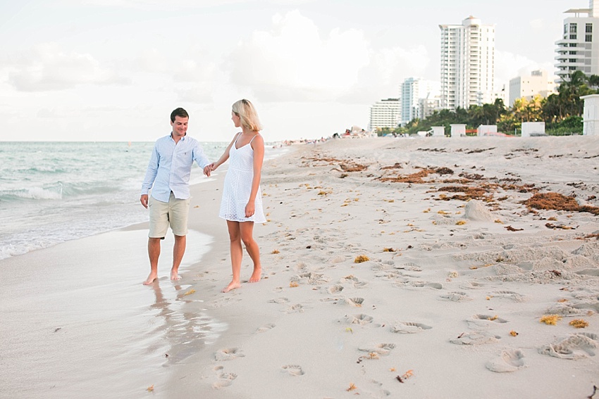 Couple holding hands and walking on south beach